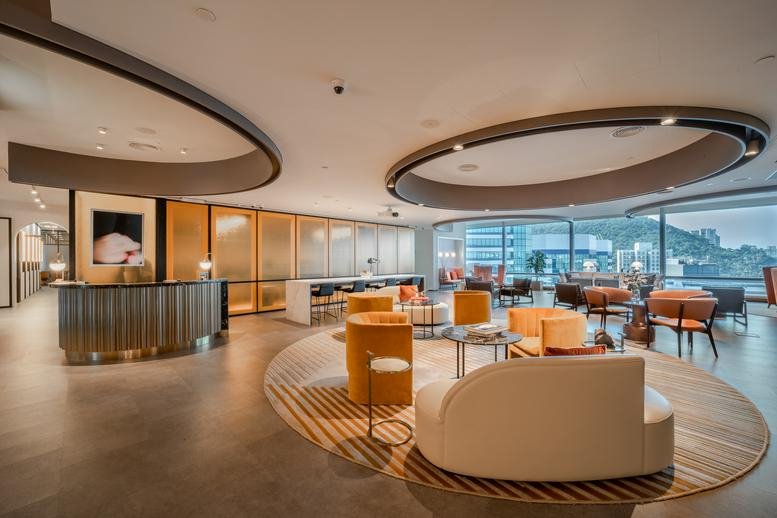 Spacious reception and lounge at One Taikoo Place with curved ceiling features and warm lighting.