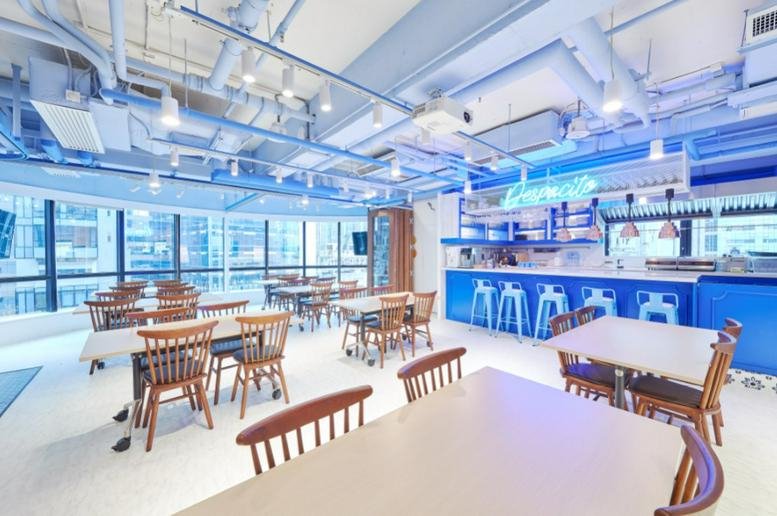 Spacious communal breakout area with blue accents and café seating at Silver Fortune Plaza.