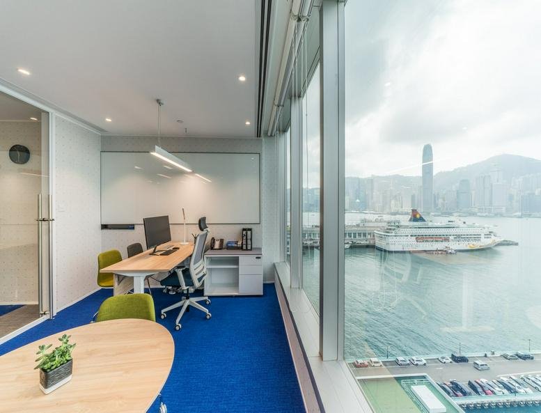 Bright corner office at The Gateway Tower 5 featuring blue carpets and panoramic harbour views.