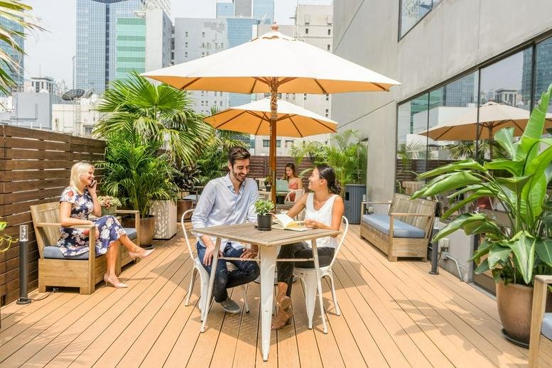 Spacious rooftop terrace with umbrellas and greenery at The Phoenix Building, 23 Luard Road.