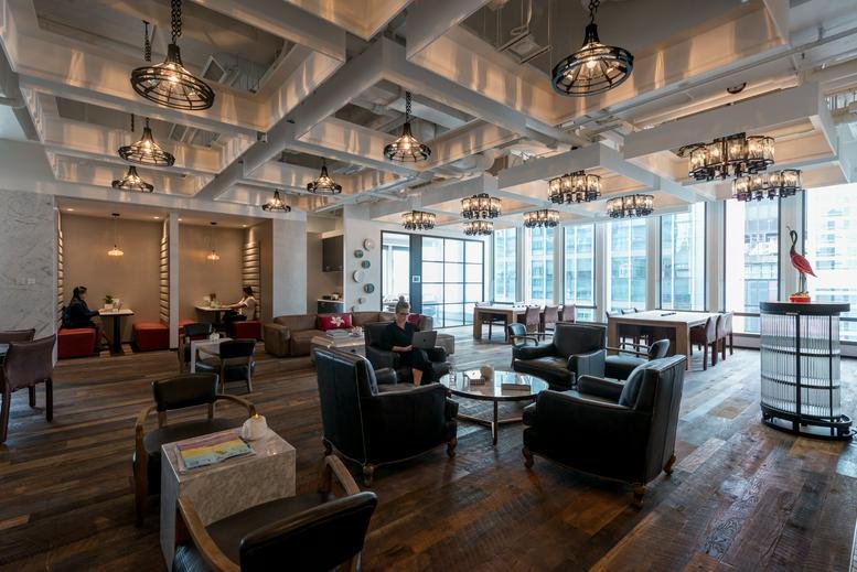 Spacious communal lounge at Two Chinachem Central with warm lighting and wooden floors.