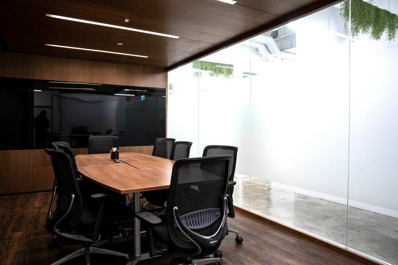 Sleek wooden boardroom with a long table and black mesh chairs at United Centre, 95 Queensway.
