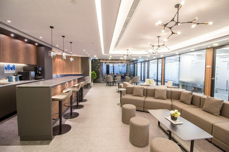 Spacious communal lounge at Wing On Centre with modern lighting and a refreshment bar.