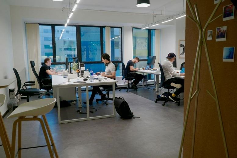 Wide view of the open-plan workspace at Workington Tower with several desks and large windows.