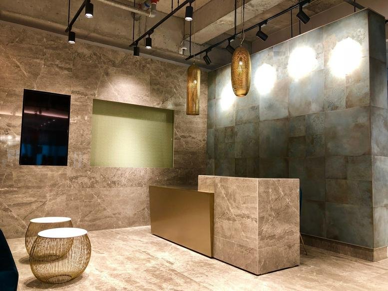 Modern reception area at YHC Tower, 1 Sheung Yuet Road with stone-textured walls and gold accents.