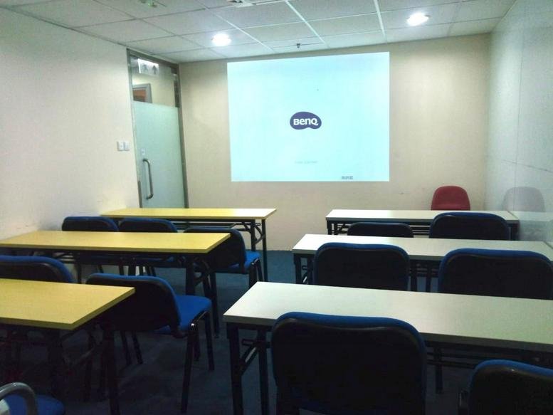 Classroom-style training room at China United Plaza with rows of desks and a projector screen.