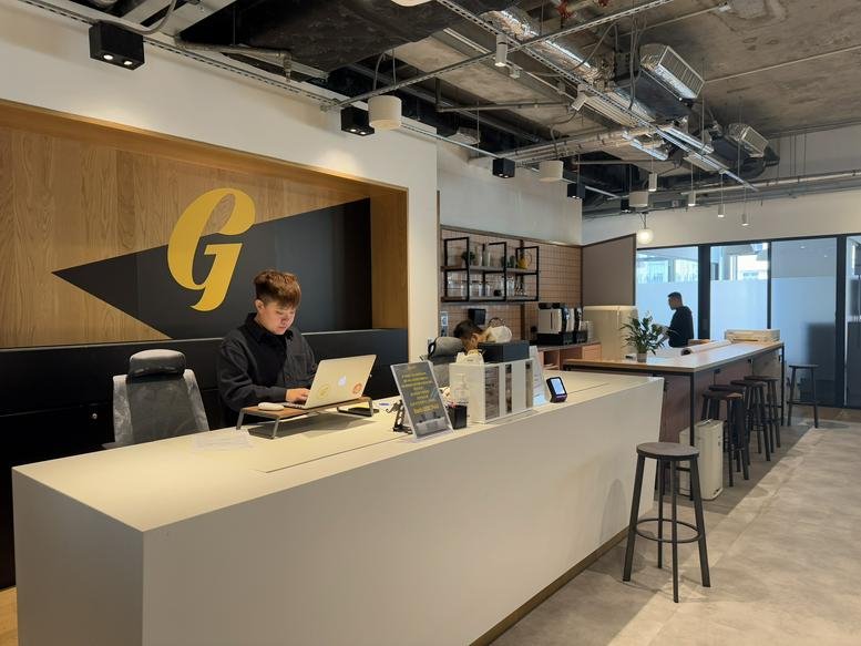 Spacious reception area at Tower 535 with a modern desk and large brand logo.