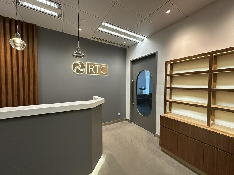 Reception desk at AIA Kowloon Tower featuring wood paneling and a branded grey wall.