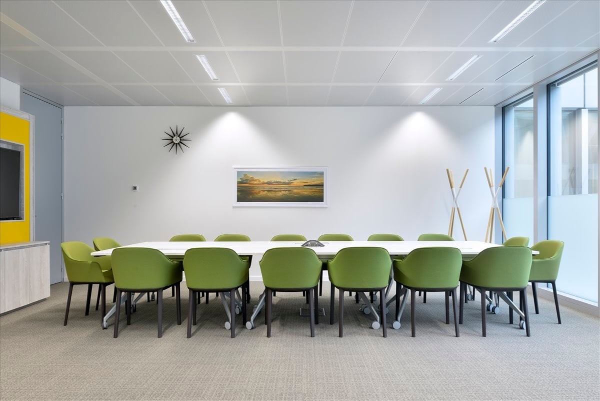Spacious boardroom at Nam Wo Building with lime green chairs and a long white conference table.