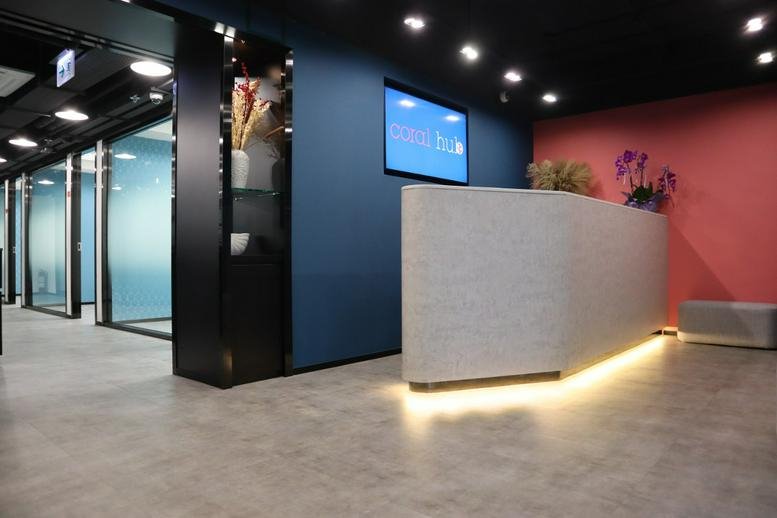 Reception desk at Roxy Industrial Centre featuring a backlit curved counter and blue feature wall.
