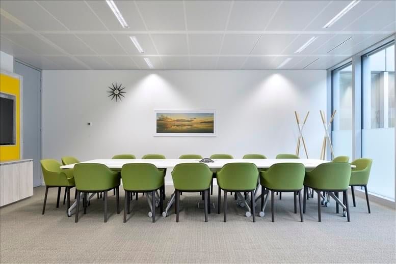 Large conference room with a long white table and green chairs.