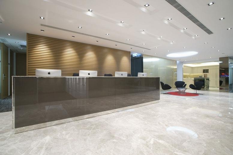 Modern reception lobby at AIA Tower with a sleek dark wood desk and marble floors.