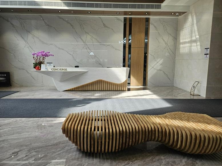 Grand entrance lobby of First Group Centre at 23 Wang Chiu Road with a unique slatted wooden bench.